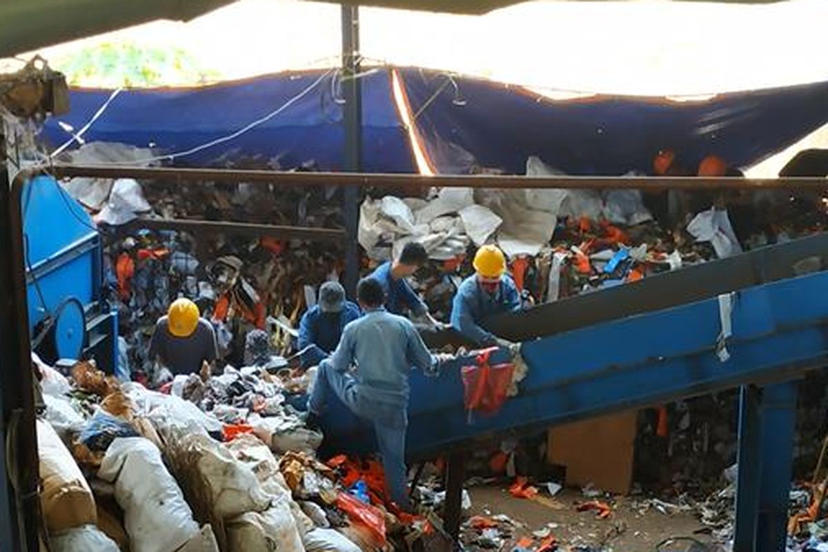 Petugas memasukkan sampah ke conveyer PLTSa Sumur Batu, Jumat (2/8/2019).