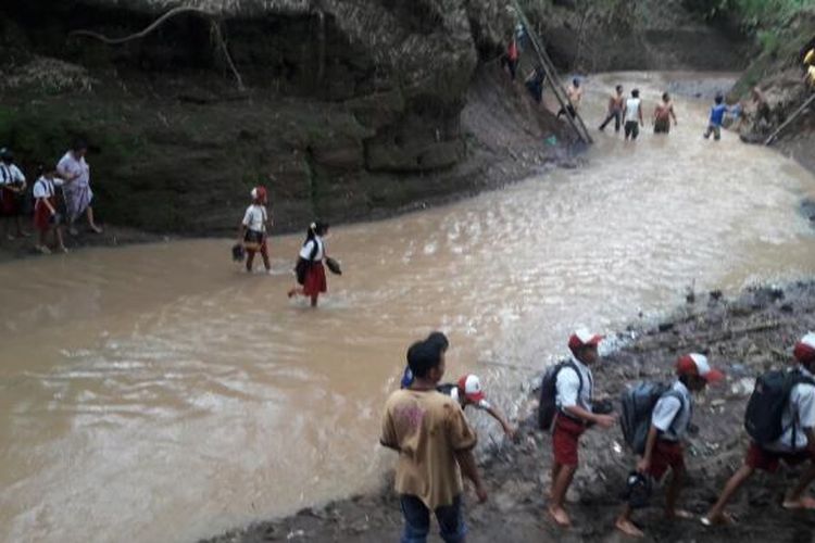 Sejumlah siswa SDN 4 Grati Kecamatan Grati Kab. Pasuruan setiap harinya harus menyebrangi sungai paska jembatan penghubung ambrol tersapu banjir