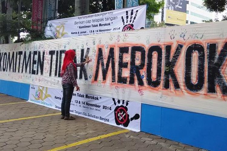 Seorang wanita memberikan cap tangan pada kain atau spanduk putih bertuliskan Komitmen Tidak Merokok di Gedung Kementerian Kesehatan RI, Jakarta, Jumat (14/11/2014).