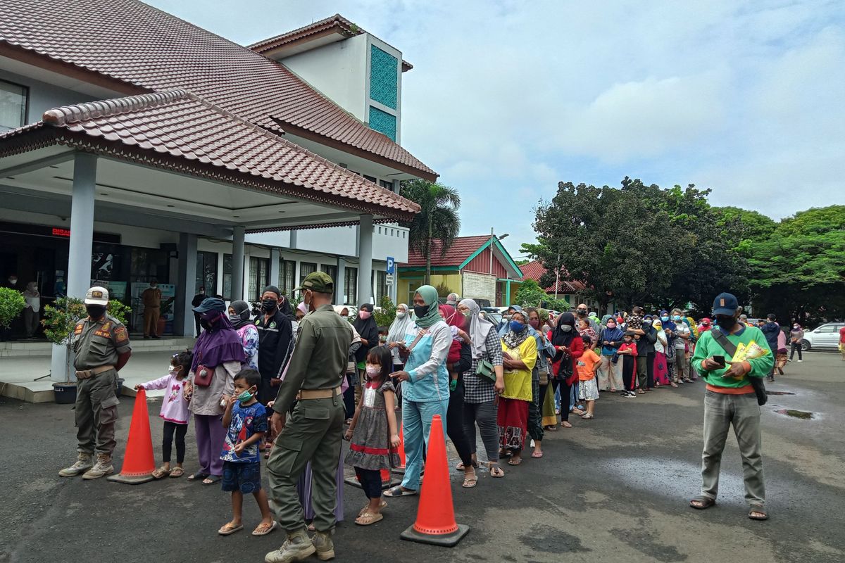 Warga mengantre untuk membeli minyak goreng murah dalam operasi pasar di Kantor Kecamatan Pamulang, Tangerang Selatan, Selasa (11/1/2022).