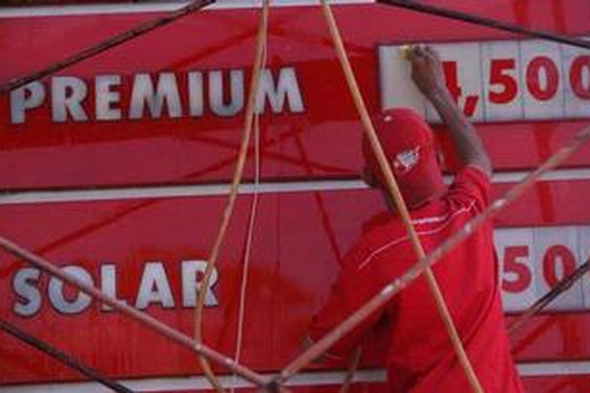 Pekerja membersihkan papan harga bahan bakar minyak (BBM) di Stasiun Pengisian Bahan Bakar untuk Umum (SPBU) 34-15319 di kawasan Alam Sutera, Tangerang Selatan, Banten, Sabtu (20/3/2013). 