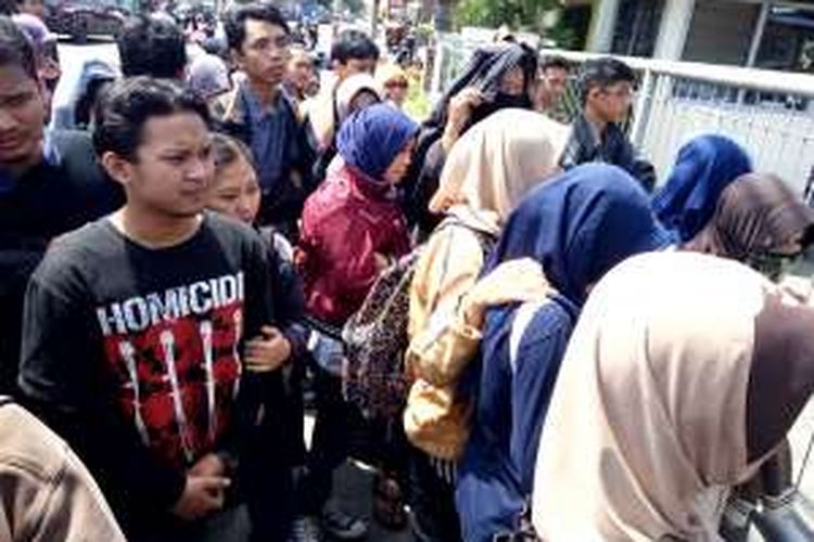 Masyarakat berjubel di depan pagar gudang PT Gramedia Asri Media, di Jalan Raya Tajem Nomor 197 Maguwoharjo, Depok, Sleman, Yogyakarta, menunggu giliran masuk.