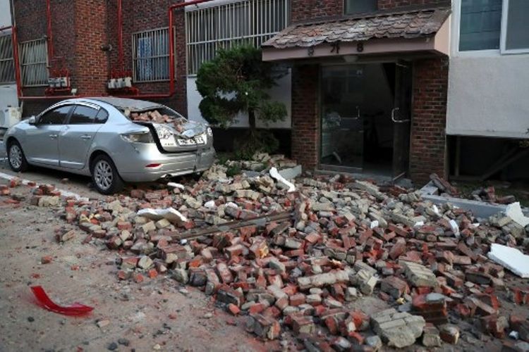 Sebuah mobil rusak terkena reruntuhan batu bata akibat gempa berkekuatan 5,4 SR di Pohang, Korea Selatan, pada Rabu (15/11/2017). (AFP/STR/YONHAP)