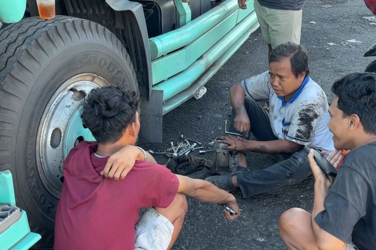 Mekanik truk sedang memperbaiki truk yang rusak dinamo starter di Dermaga Bulusan Ketapang. 