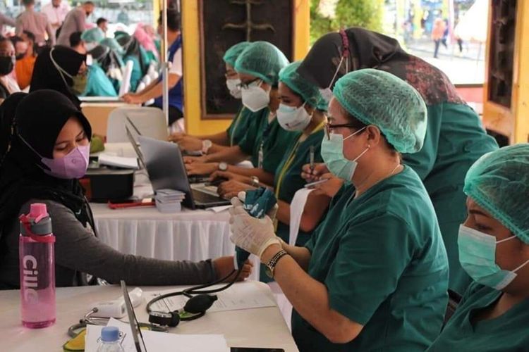 Warga mengikuti vaksinasi massal yang berlangsung di Tribun Lapangan Merdeka Ambon, Sabtu (26/6/2021)