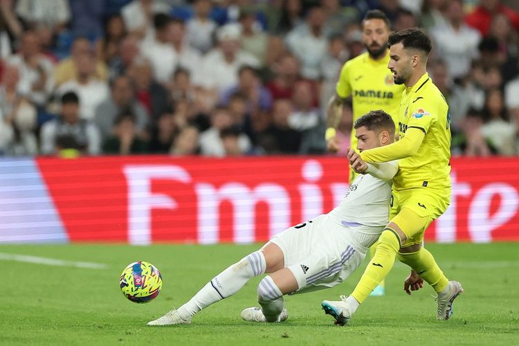 Gelandang Real Madrid Federico Valverde berduel dengn pemain Villarreal Alex Baena dalam laga lanjutan Liga Spanyol 2022-2023. Laga Real Madrid vs Villarreal berlangsung di Stadion Santiago Bernabeu pada Minggu (9/4/2023) dini hari WIB.