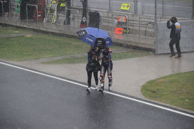 Suasana saat para pebalap dan kru tim tergesa-gesa kembali ke paddock di tengah hujan deras yang mengguyur kawasan Sirkuit Mandalika jelang Race 1 kelas World Superbike, Sabtu (20/11/2021).