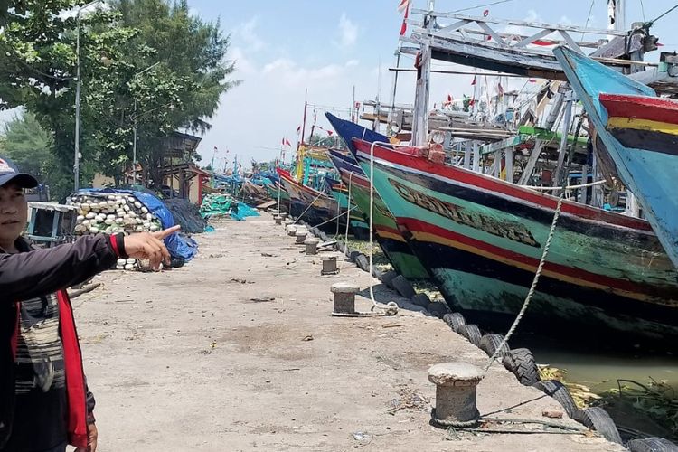 Ketua HNSI Pemalang Abul Hasan menunjukkan beberapa kapal nelayan yang berhenti melaut imbas kenaikan BBM di Pelabuhan Tanjungsari, Pemalang 