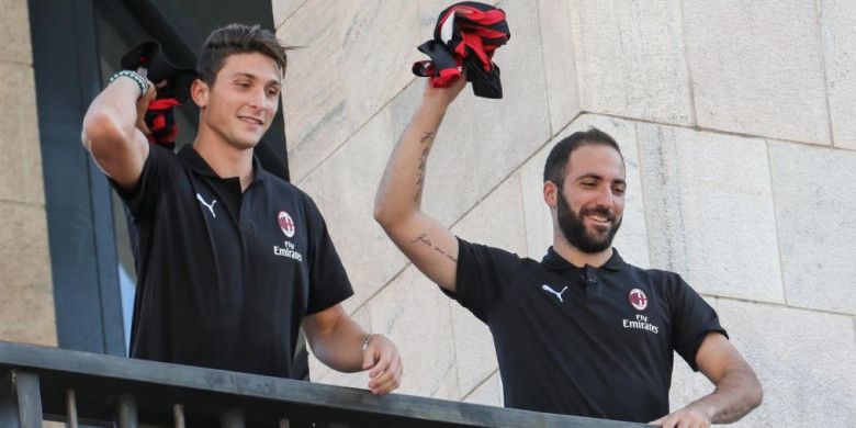 Dua pemain baru AC Milan, Gonzalo Higuain (kanan) dan Mattia Caldara, menyapa fans saat diperkenalkan di balkon Piazza Duomo, Milan, 3 Agustus 2018.
