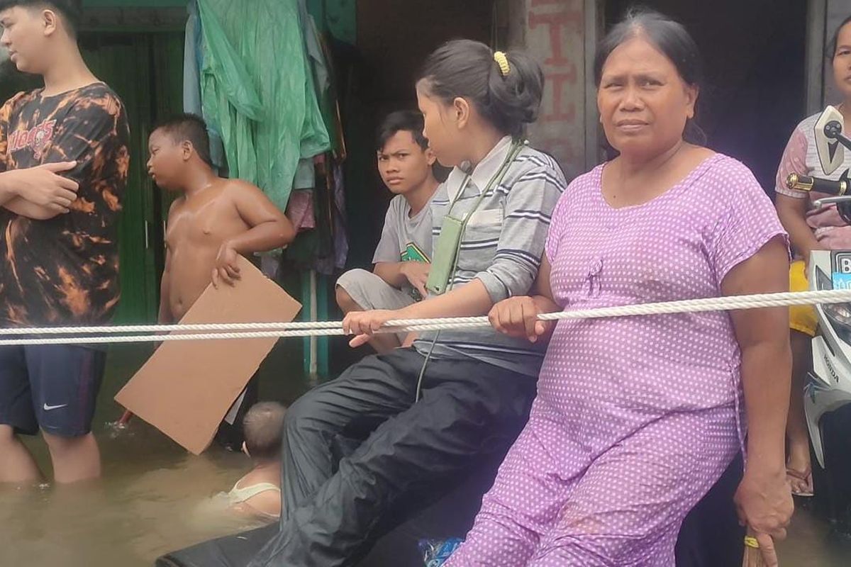 Warga di RW 08 Kelurahan Ancol, Pademangan, Jakarta Utara, memasang tali pegangan di Jalan Lodan Raya karena arus banjir rob yang cukup deras.