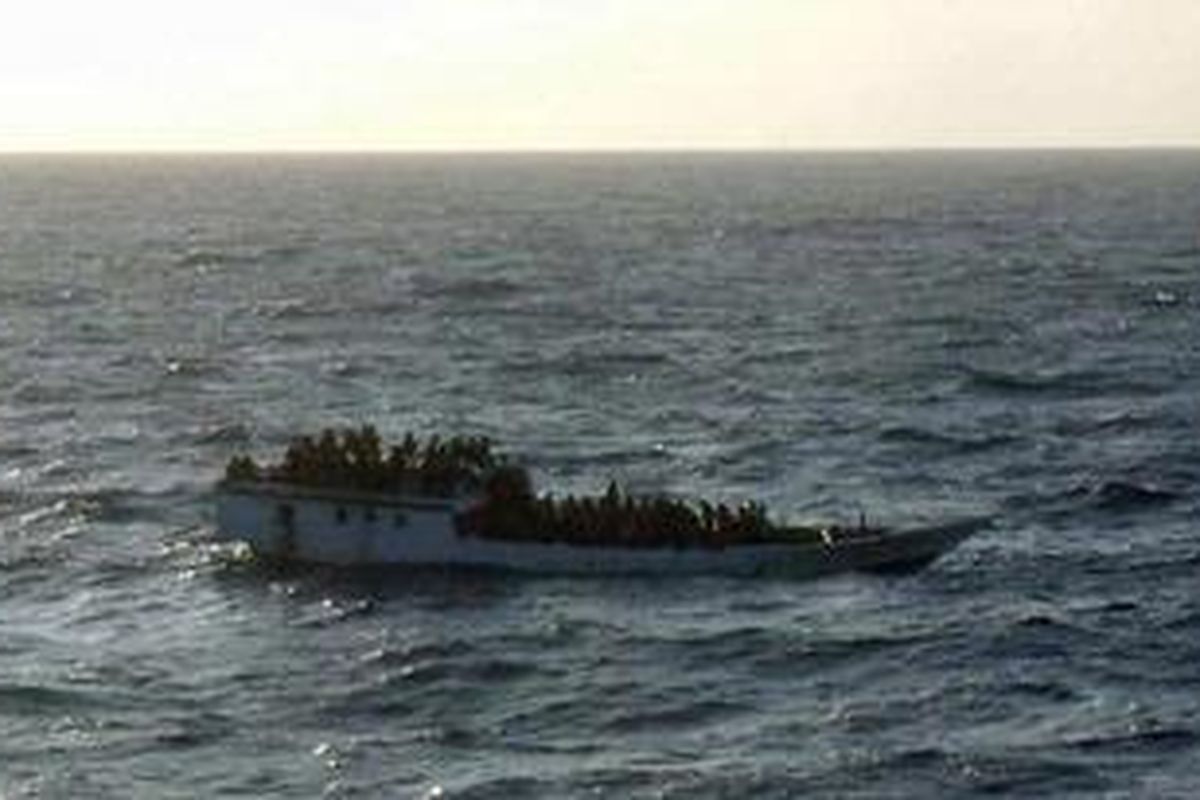 Foto yang diambil kru kapal MV Bison Express, dan dirilis Otoritas Keselamatan Maritim Australia (AMSA),  menunjukkan kapal kecil disesaki lebih dari 100 pencari suaka ke Australia. Kapal itu terbalik dan tenggelam di 107 mil laut utara Pulau Christmas, Australia, Rabu (27/6/2012). MV Bison Express dan dua kapal dagang lain serta dua kapal AL Australia berhasil menyelamatkan 123 penumpang.  