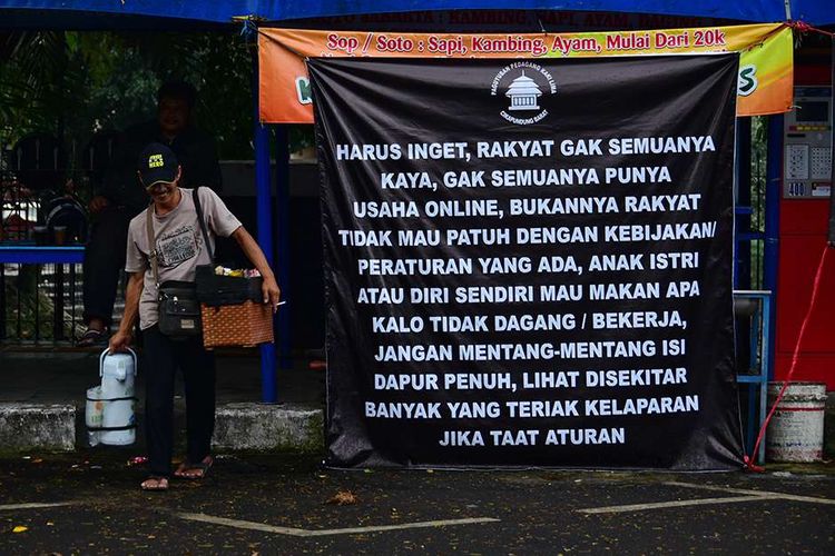 Pedagang kaki lima (PKL) yang berada di Jalan Cikapundung Barat, Kota Bandung, Jawa Barat, melakukan aksi pasang bendera putih di kios mereka, menyusul pemberlakuan PPKM Darurat, Senin (19/7/2021). Bendera putih yang dikibarkan 104 pedagang itu merupakan tanda mereka tak lagi sanggup menghadapi Covid-19 yang telah menghancurkan perekonomian.