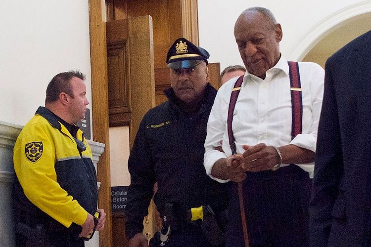 Dengan tangan diborgol, aktor komedi Bill Cosby digiring keluar dari ruang sidang di Pengadilan Montgomery County, Norristown, Pennsylvania, Selasa (25/9/2018). Ia dijatuhi hukuman 3 hingga 10 tahun penjara dalam perkara serangan seksual. 
