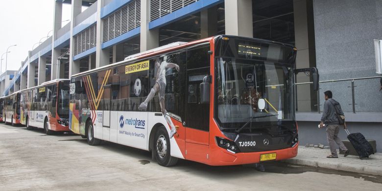 Calon penumpang berjalan di dekat bus Metrotrans saat uji coba integrasi dengan Kereta Bandara pada hari pertama di Stasiun Sudirman Baru, Jakarta, Kamis (28/12/2017). Integrasi Metrotrans dengan Kereta Bandara itu bertujuan untuk memberikan kenyamanan kepada masyarakat.  