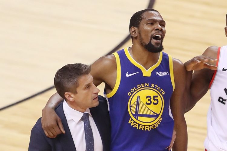 Power forward andalan Golden State Warriors, Kevin Durant, dibantu berjalan ke luar lapangan usai mengalami cedera pada gim kelima Final NBA 2019 melawan Toronto Raptors, di Scotibank Arena, Toronto, Kanada, Senin (10/6/2019).