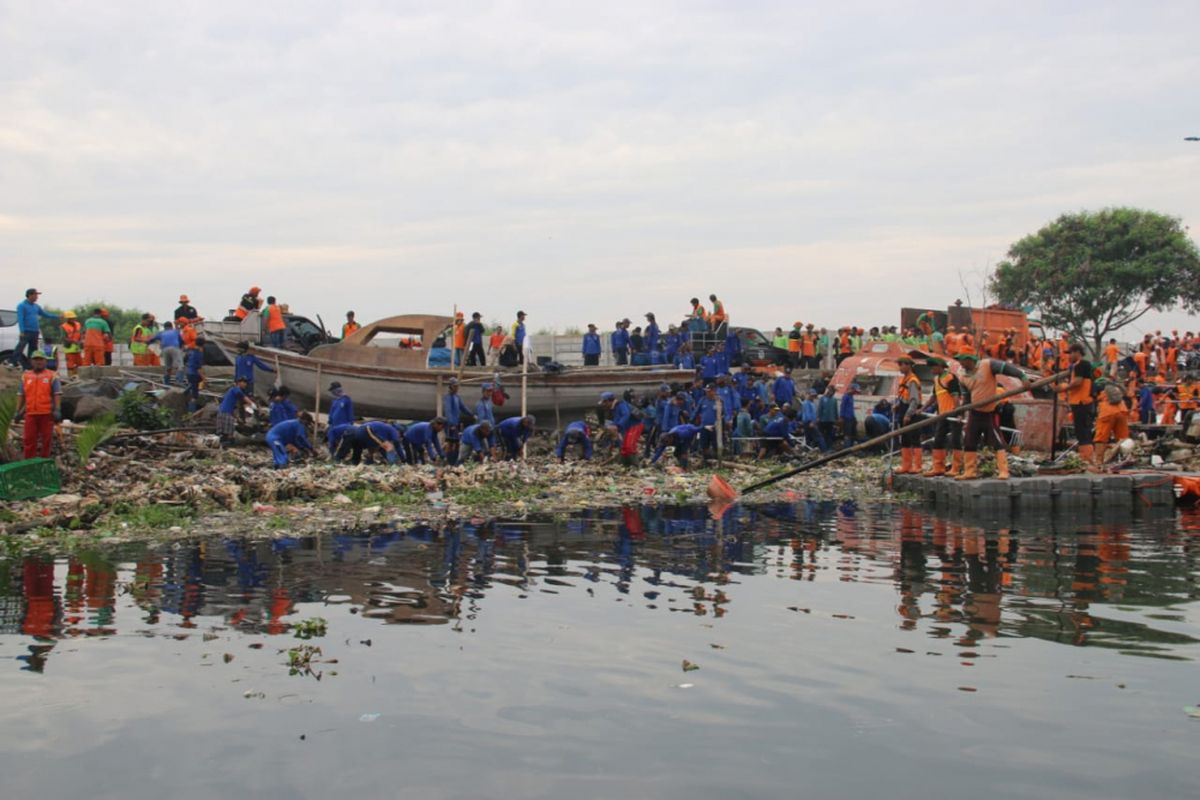 Petugas melakukan pembersihan sampah di pesisir Marunda Kepu, Cilincing, Minggu (10/3/2019).
