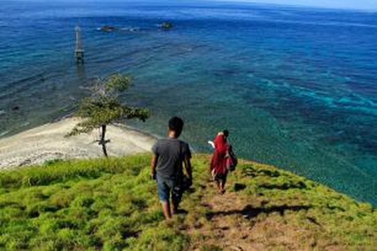 Pengunjung sedang menuruni punggung Pulau Baling-Baling di Kecamatan Posomaen, Kabupaten Minahasa Tenggara, Sulawesi Utara.