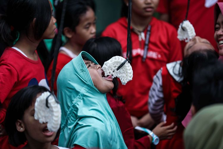 Anak-anak kecil melakukan lomba makan kerupuk untuk memeriahkan HUT ke-74 Kemerdekaan RI di kawasan Petamburan, Tanah Abang, Jakarta, Sabtu (17/8/2019).