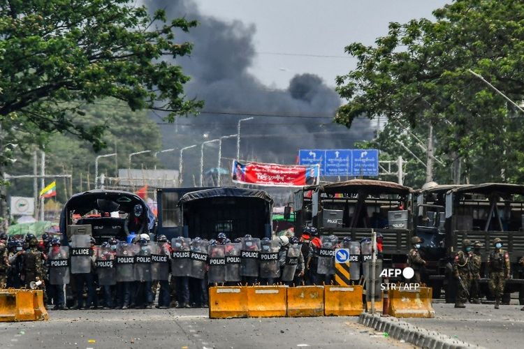 Security forces stand guard during a demonstration by protesters against the military coup in Yangon's Hlaing Tharyar township on March 14, 2021. (Photo by STR / AFP)