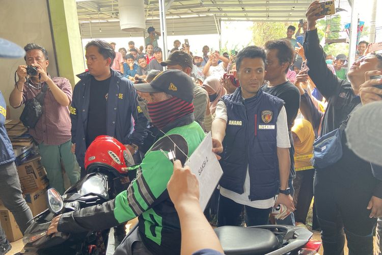 Adin (40) driver ojol yang jadi saksi kasus pembunuhan mayat dalam kardus melakukan reka adegan, Selasa (5/8/2025)