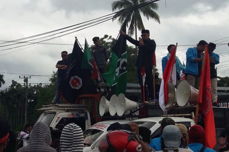 Anggota DPRD Sultra Sudirman berorasi menolak kedatangan TKA di perempatan Bandara Haluoleo Kendari
