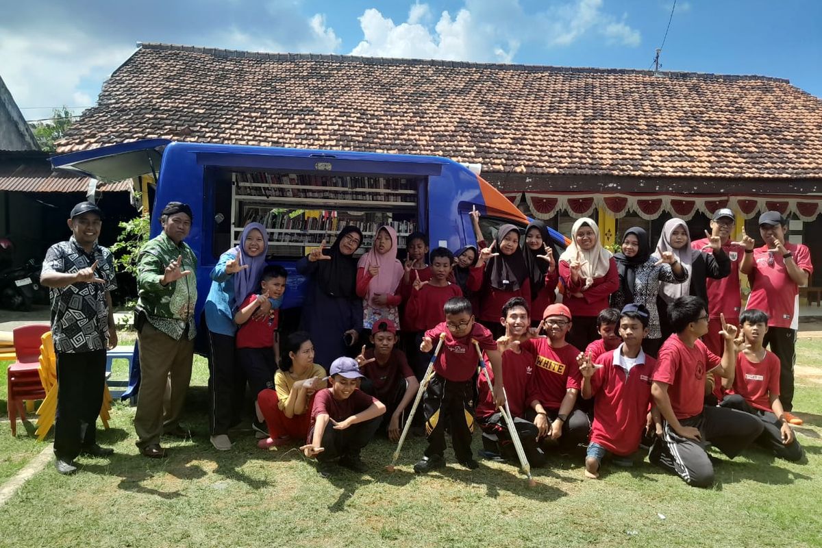 Saat Pak Ipong dan tim Perpusda Sumenep foto bersama dengan anak-anak disabilitas usai kegiatan membaca bersama di Sumenep, Jawa Timur. 