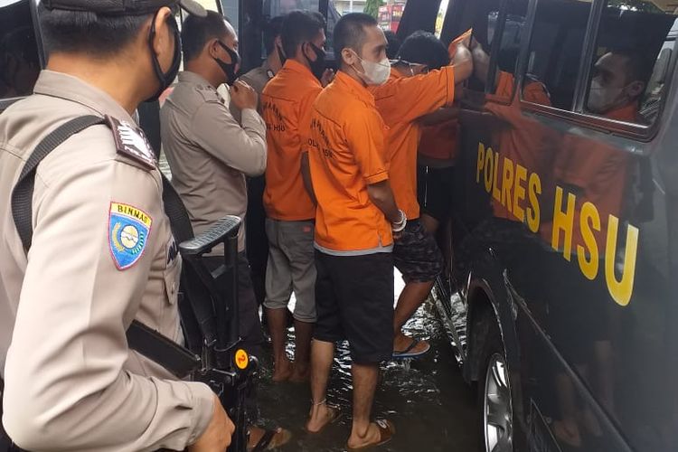 Petugas Sabhara Polres HSU bersenjata lengkap mengawal 11 tahanan yang dipindahkan setelah Polres HSU terdampak banjir. 