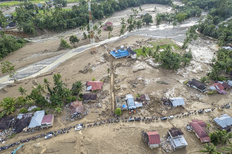 Foto udara antrean kendaraan warga melintasi jalan kawasan permukiman Jorong Kayu Pasak yang rusak akibat banjir bandang di Nagari Salareh Aia, Palembayan, Agam, Sumatera Barat, Minggu (30/11/2025). Rusak dan menyempitnya akses jalan akibat lumpur dan material lain di sejumlah titik menuju lokasi terdampak banjir bandang yang terjadi pada Kamis (27/11) di daerah itu mengakibatkan terjadinya antrean panjang kendaraan, sementara BPBD Kabupaten Agam mencatat sepanjang 2.801 meter jalan di kabupaten itu rusak  dengan nilai kerugian mencapai Rp3,45 miliar. 