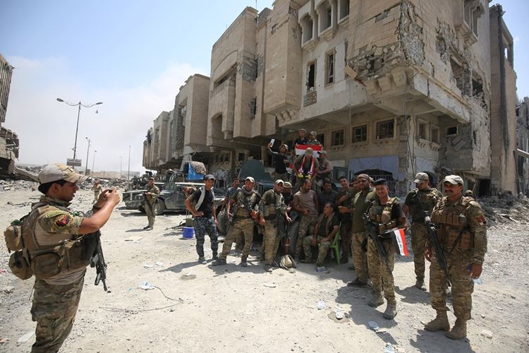 Sekelompok prajurit Irak berfoto bersama di Kota Tua Mosul setelah tugas mereka merebut kota itu dari tangan ISIS dinyatakan telah berakhir dengan kemenangan.