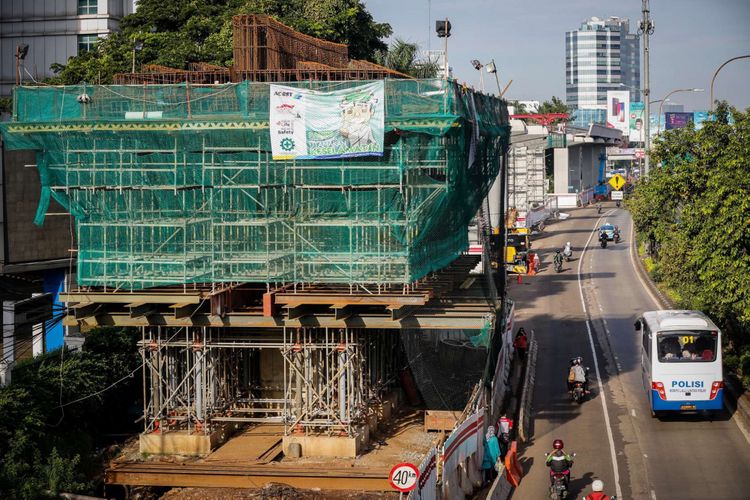 Pengendara melintas di samping lokasi pembangunan Light Rail Transit (LRT) Cawang-Pancoran di Jakarta, Sabtu (24/2/2018). Progres proyek pembangunan kereta api ringan atau Light Rail Transit (LRT) tahap I yang meliputi relasi Cibubur-Cawang, Bekasi Timur-Cawang dan Cawang-Dukuh Atas secara keseluruhan mencapai 20 persen dan ditargetkan selesai pada 2019.