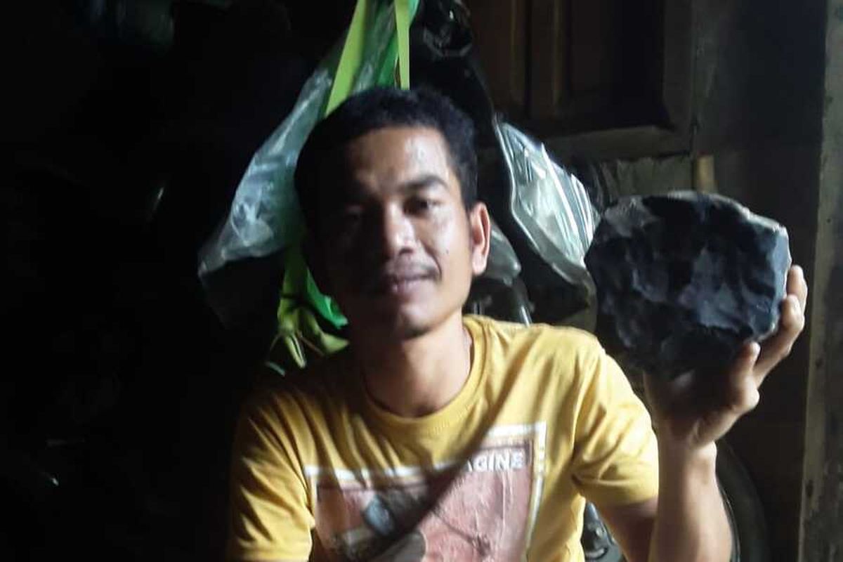 Josua Hutagalung (33) warga Dusun Sitahan Barat, Desa Satahi Nauli, Kecamatan Kolang, Kabupaten Tapanuli Tengah menunjukkan batu yang diduganya sebagai meteor setelah jatuh menimpa rumahnya, Sabtu (1/8/2020).