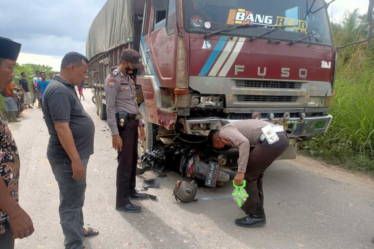 Petugas kepolisian lalu lintas Polres Rokan Hulu melakukan olah tempat kejadian perkara (TKP) pada kecelakaan lalu lintas antara sepeda motor dengan truk fuso, di Desa Bonai, Kecamatan Bonai Darussalam, Kabupaten Rokan Hulu, Riau, Jumat (22/10/2021).