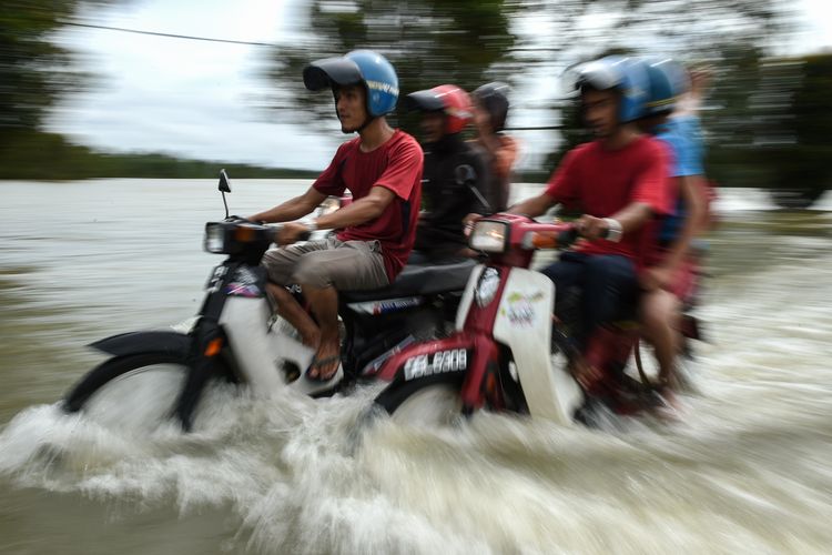 Warga mengendarai motor saat melintasi banjir di Jal Besar, Malaysia, Kamis (5/1/2017). Banjir musiman selalu melanda wilayah timur laut Malaysia setiap tahun dan mengakibatkan evakuasi massal.