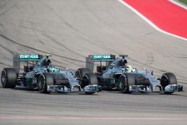 Pebalap Mercedes asal Inggris, Lewis Hamilton (kanan), menyalip rekan satu timnya, Nico Rosberg, pada GP AS yang berlangsung di Sirkuit Americas, Minggu (2/11/2014).
