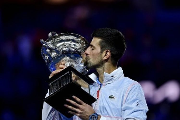 Petenis Serbia, Novak Djokovic, mencium trofi Australian Open. Djokovic tampil sebagai juara Australian Open 2023 usai mengalahkan petenis Yunani, Stefanos Tsitsipas, pada laga final yang digelar di Rod Laver Arena, Melbourne Park, pada Minggu (29/1/2023).