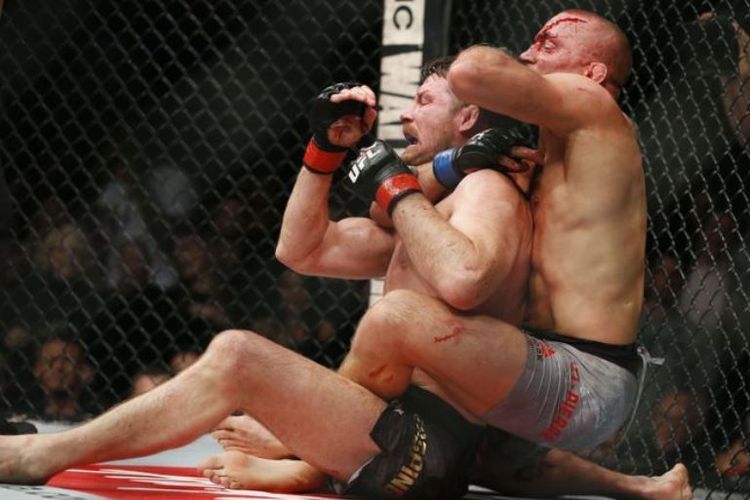 Georges St-Pierre (kanan) mencekik Michael Bisping (kiri) dalam ajang UFC 127, sabtu (04/11/2017).