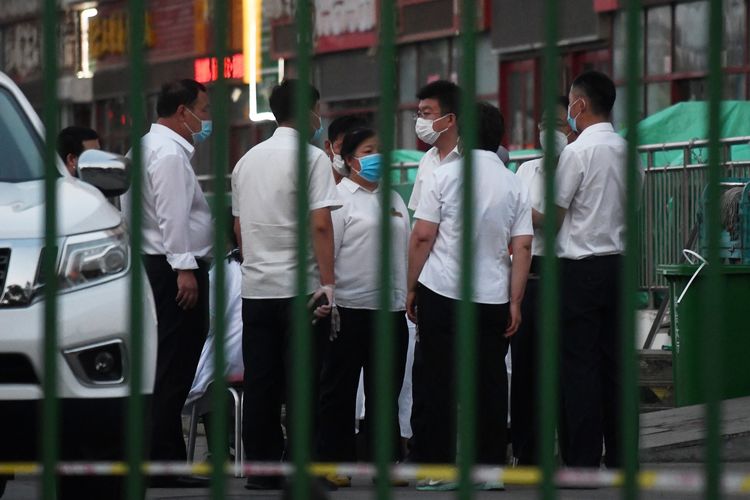Pejabat setempat berkumpul di luar pasar grosir Xinfadi di Beijing, China, pada 12 Juni 2020. Pasar Xinfadi dan pasar seafood Jingshen ditutup setelah munculnya kasus baru virus corona.