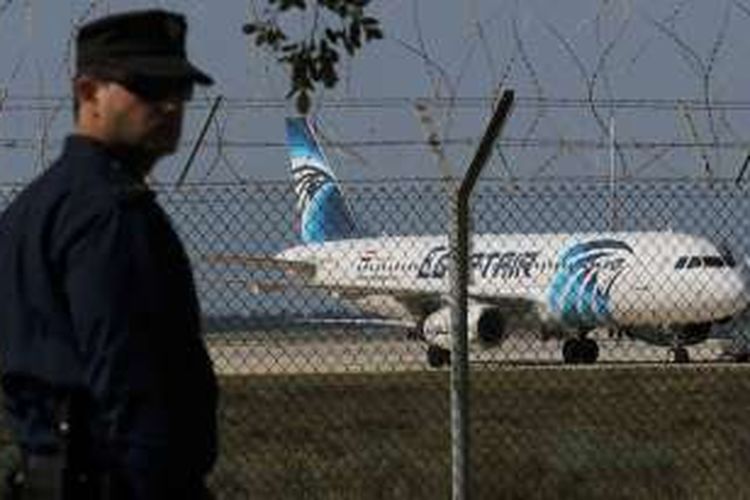 Seorang polisi berjaga di bandara Larnaca, Siprus, tempat sebuah pesawat milik maskapai Egypt Air dibajak. 