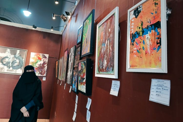 Seorang pengunjung melihat hasil karya lukisan dua pelukis cilik down syndrome di Galeri Merah utih Balai Pemuda Surabaya yang berlangsung mulai tanggal 14-20 Juni 2025.