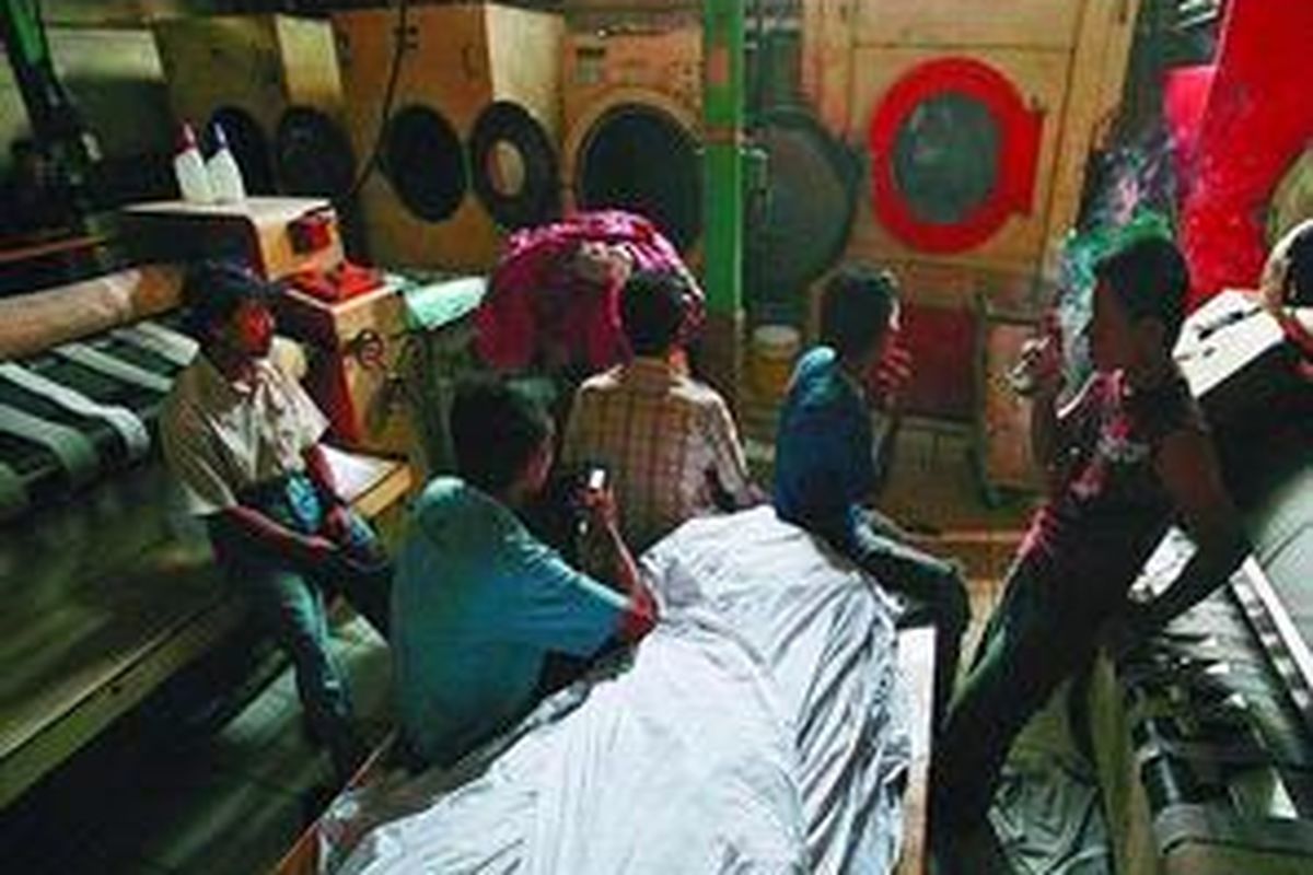 Pekerja laundry Saporette menunggu waktu di antara cucian yang menumpuk karena pemadaman bergilir di kawasan Kemanggisan, Jakarta Barat, Rabu (11/11). Akibat pemadaman lebih dari 4 jam, pemilik laundry harus menanggung rasa kecewa pelanggannya yang terdiri dari sejumlah hotel akibat cucian terlambat dan biaya ekstra lembur 30 karyawannya untuk bekerja hingga pagi.