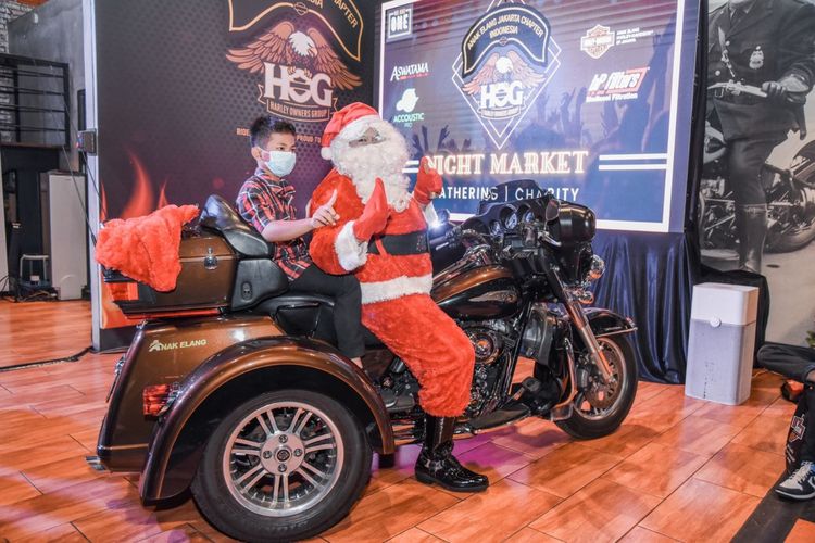 Seorang anak berfoto naik Harley Davidson dalam acara Christmas Charity dan Night Market yang digelar HOG Anak Elang Jakarta Chapter.