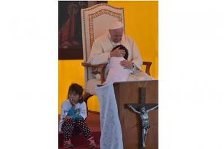 Paus Fransiskus memeluk seorang anak dari salah satu narapidana di LP Palmasola, Santa Cruz de la Sierra, Jumat (10/7/2015).