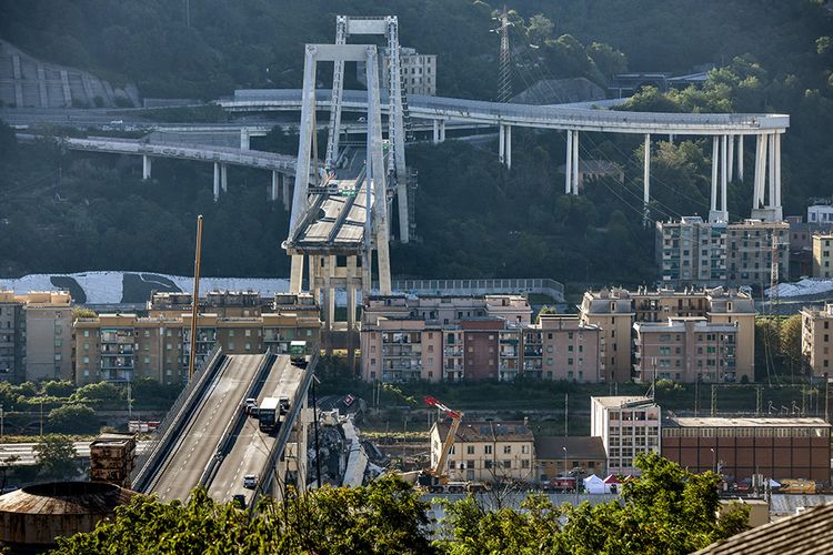 Kondisi Jembatan Morandi di Kota Genoa, Italia, yang ambruk pada Selasa (14/8/2018). Kantor berita ANSA menyebut sedikitnya 39 orang tewas akibat ambruknya salah satu seksi jembatan sepanjang 1.100 meter itu setelah hujan lebat yang mengguyur Selasa siang, waktu setempat.