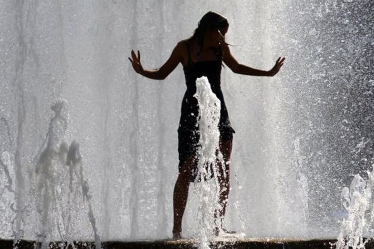 Seorang perempuan mendinginkan tubuh di pancuran Kota Praha, Republik Ceko, saat suhu mencapai 38 derajat Celcius.  