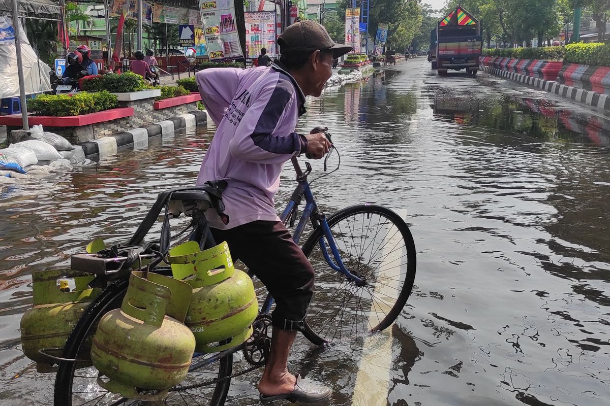 Sugiono (60) seorang pengecer gas elpiji 3 kilogram yang menerjang banjir di Jalan Sultan Fatah Demak, Selasa (19/3/2024). (KOMPAS.COM/NUR ZAIDI)