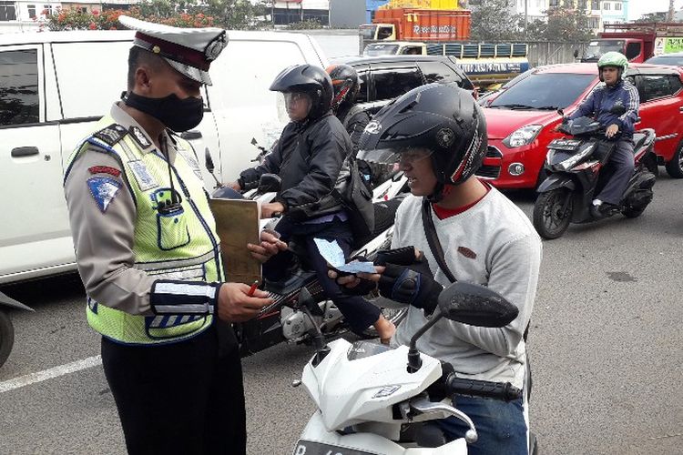 Petugas gabungan dari Samsat, Polisi, Jasa Raharja dan Bank DKI melakukan razia pengesahan Surat Tanda Nomor Kendaraan (STNK) di Jalan Tol Lingkar Luar Jakarta, pintu masuk tol Cengkareng Barat, Cengkareng, Jakarta Barat pada Rabu (25/7/2018).