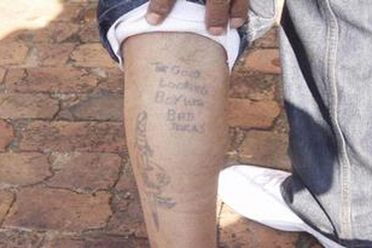 Seorang mantan anggota geng menunjukkan tato khas anggota gengnya.