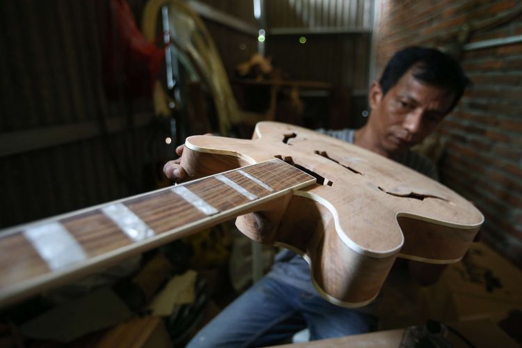 Pendiri NA Custom, Yatna, tengah menyelesaikan pembuatan gitar custom di workshopnya di Pabuaran, Cikeas Udik, Kabupaten Bogor, Sabtu (26/9/2020). Selain pelanggan lokal, gitar custom bikinan Yatna juga dipesan oleh pelanggan di Amerika, Rusia, Jepang, Malaysia, dan Arab. Sebuah gitar custom dijual mulai dari harga Rp. 3.000.000.
