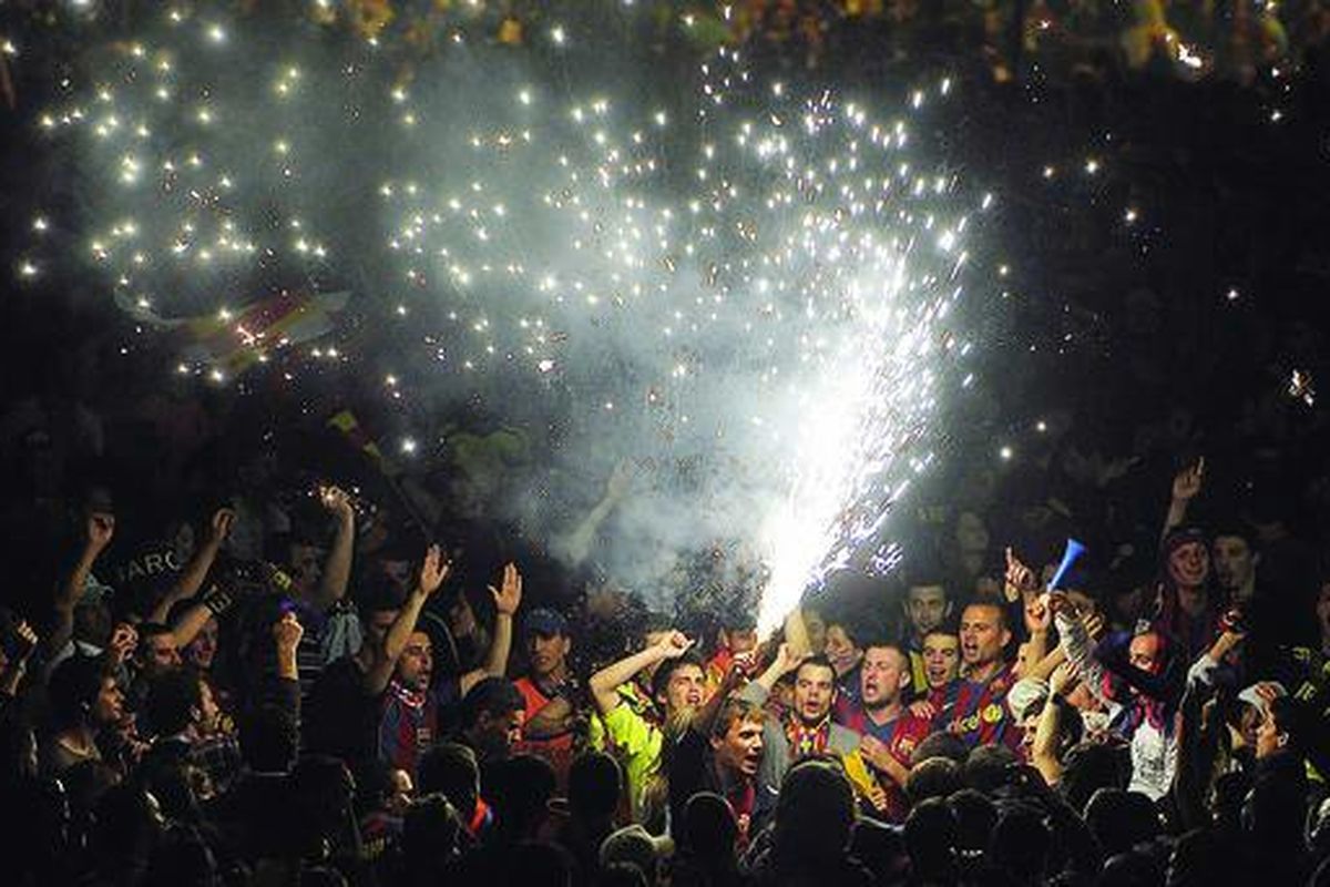 Penggemar Barcelona menyalakan api suar saat merayakan kemenangan tim mereka yang menjuarai Liga Spanyol di Barcelona, Spanyol, Senin (17/5).