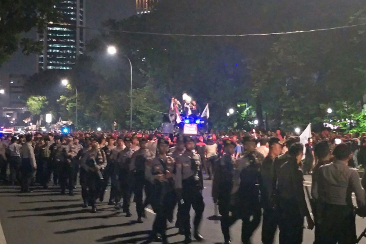Polisi menahan buruh yang hendak menuju Balai Kota DKI Jakarta di Jalan Medan Merdeka Selatan, Jumat (10/11/2017) malam.